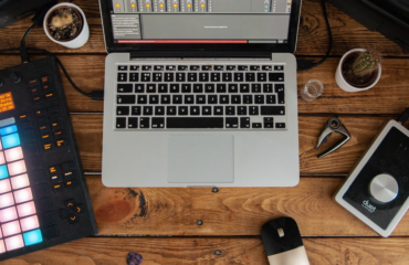 musical instruments and laptop on wooden table